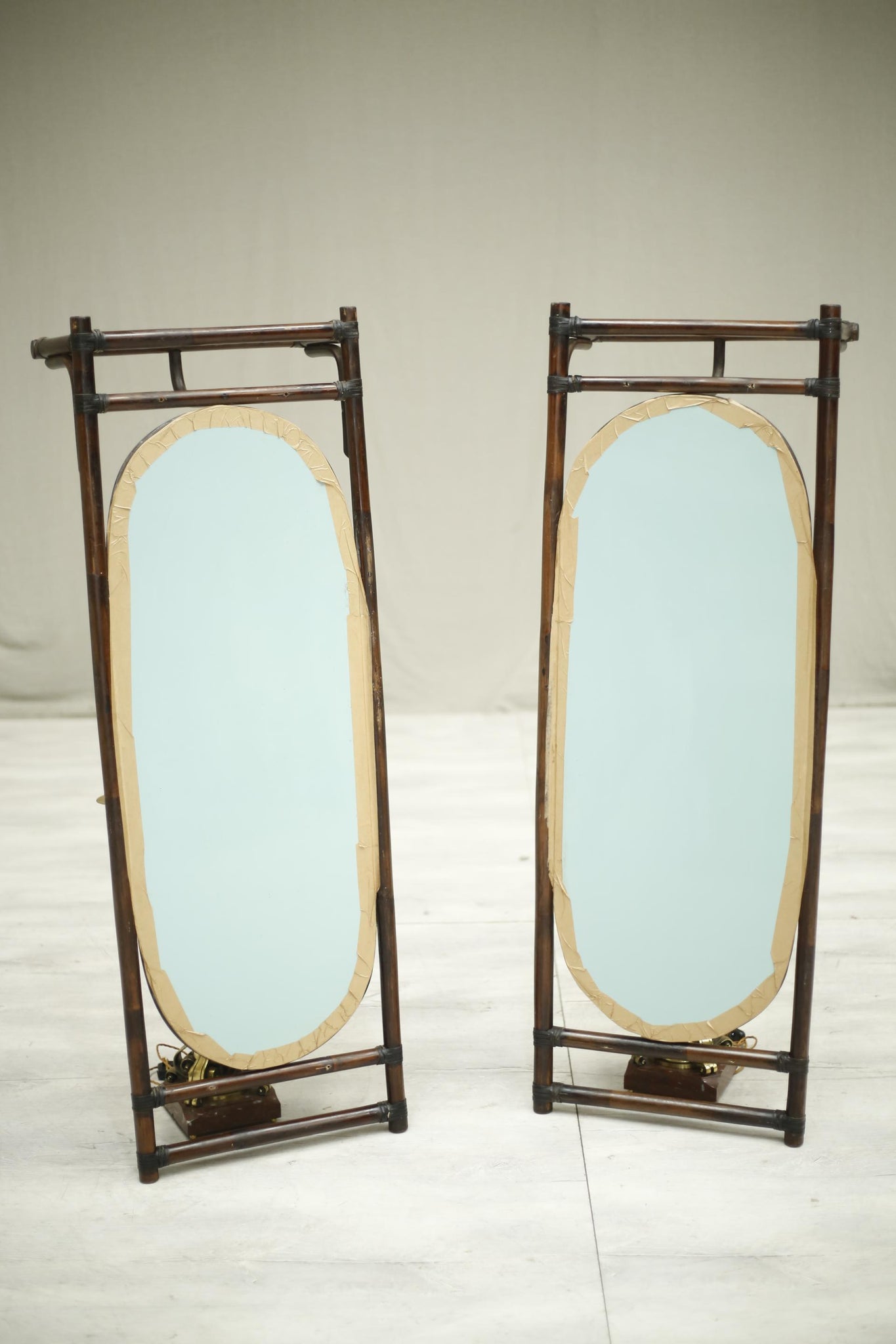 Pair of mid 20th century bamboo mirrors with luggage shelf