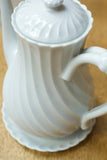 Vintage white porcelain coffee pot with saucer