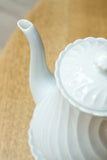 Vintage white porcelain coffee pot with saucer