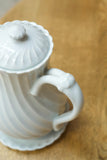 Vintage white porcelain coffee pot with saucer