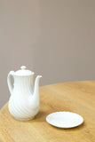 Vintage white porcelain coffee pot with saucer